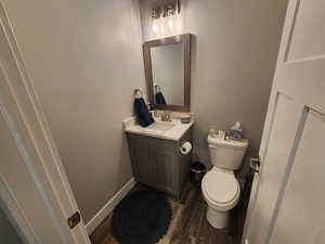 Bathroom with hardwood / wood-style flooring, toilet, and vanity