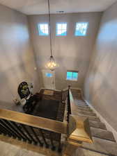 Entryway featuring carpet floors, a high ceiling, and a chandelier