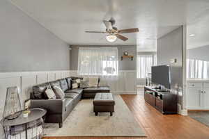 Living room featuring ceiling fan, light hardwood / wood-style flooring, and a textured ceiling