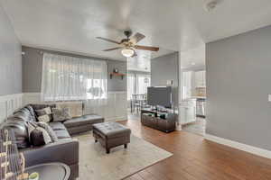 Living room with ceiling fan and light hardwood / wood-style flooring