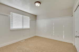 Unfurnished bedroom featuring light colored carpet