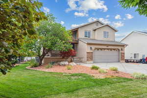 Front facade featuring a garage and a front lawn