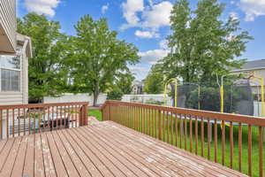 Deck featuring a trampoline and a lawn