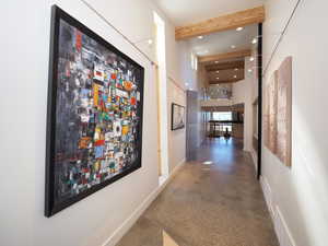 Hallway with a high ceiling and beamed ceiling