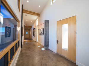 Hall featuring beam ceiling and high vaulted ceiling