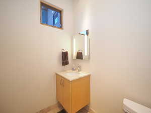 Bathroom featuring tile patterned floors, vanity, and toilet