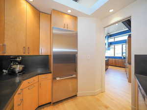 Kitchen with light hardwood / wood-style flooring and built in fridge