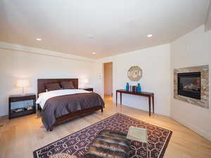 Bedroom with light wood-type flooring and a fireplace