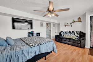 Bedroom with ceiling fan, a textured ceiling, and light LVP floors