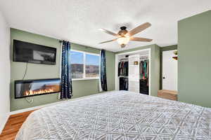 Bedroom featuring ceiling fan, a closet, a textured ceiling, and LVP floors