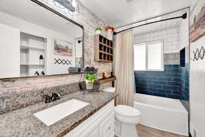 Full bathroom with toilet, tile flooring, vanity, and shower / bath combo with shower curtain- completely remodeled