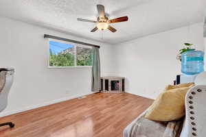 Interior space featuring light LVP flooring, ceiling fan, and a textured ceiling