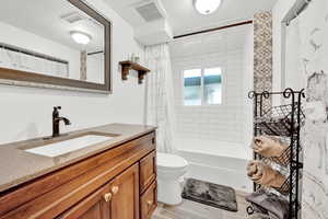 Full bathroom with shower / bath combination with curtain, vanity, and toilet. Completely remodeled