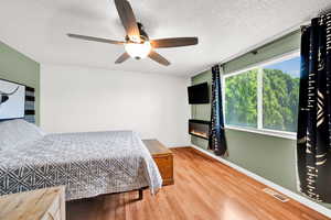 Bedroom featuring ceiling fan, a textured ceiling, and LVP floors