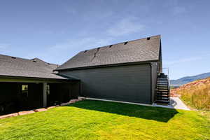 Rear view of property featuring a covered patio, yard and a mountain view