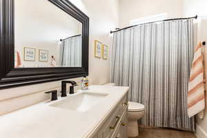 Bathroom 3 with hardwood / wood-style floors, toilet, vanity, and a shower with curtain