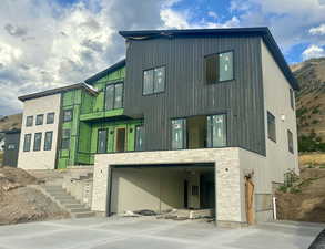 View of front facade of the property- garage, deck and front entrance.