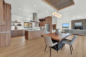 Dining area with light hardwood / wood-style flooring and a tiled fireplace