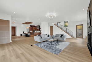 Living room with light hardwood / wood-style floors and an inviting chandelier