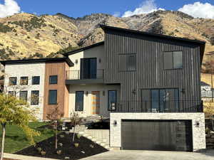 Modern home with a balcony, a garage, and a mountain view