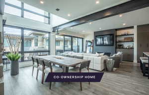 Dining space with a fireplace, light hardwood / wood-style flooring, and ceiling fan