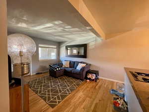 Living room with beam ceiling and wood-type flooring