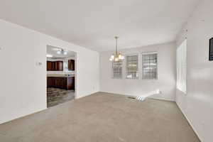 Carpeted empty room with a chandelier