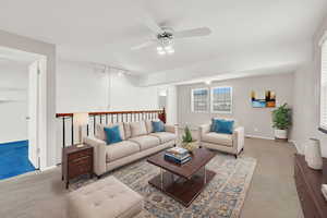 Digitally staged Carpeted living room featuring ceiling fan and rail lighting