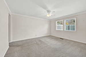 Unfurnished room featuring ceiling fan, ornamental molding, and light carpet