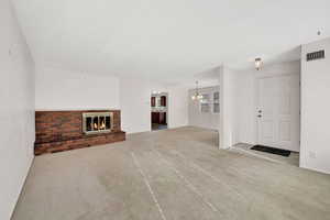 Unfurnished living room featuring a fireplace and light carpet