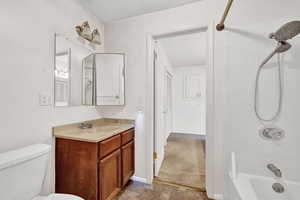 Full bathroom with toilet, vanity, and tiled shower / bath