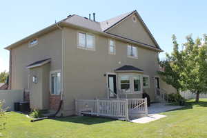 Back of property featuring a lawn and a patio