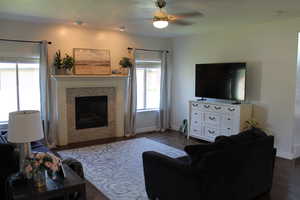 Living room with ceiling fan and dark hardwood / wood-style flooring