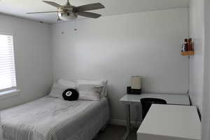 Bedroom featuring ceiling fan and multiple windows