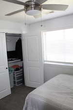 Bedroom featuring ceiling fan, a closet, and carpet