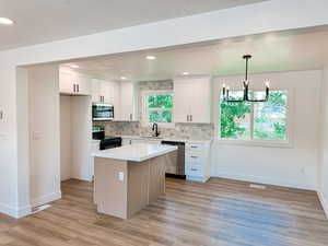 Kitchen with a wealth of natural light, appliances with stainless steel finishes, sink, and light hardwood / wood-style floors