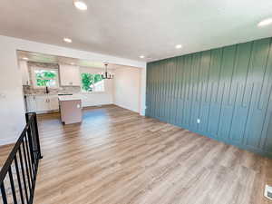 Interior space with sink, a notable chandelier, light hardwood / wood-style floors, and a textured ceiling