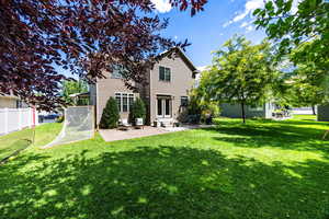 Rear view of house with a patio area and a lawn