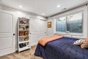 Bedroom with light carpet and a closet