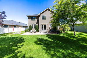 Rear view of house with a patio area and a yard