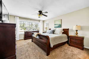 Carpeted bedroom featuring ceiling fan