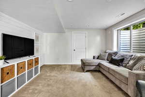 Living room featuring a textured ceiling and light carpet