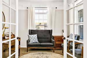 Living area with carpet and ornamental molding