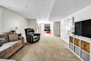 Living room with a textured ceiling and light carpet