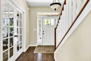 Foyer entrance with dark hardwood / wood-style flooring and french doors