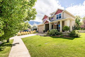 Exterior space with a lawn, a mountain view, a garage, and covered porch