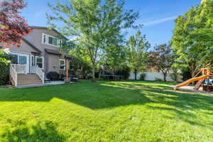 View of yard featuring a patio area, a trampoline, and a playground