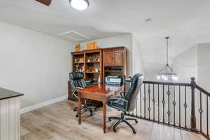 Office with light hardwood / wood-style flooring