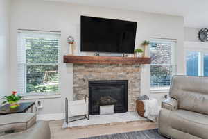 Living room with light wood-type flooring, a wealth of natural light, and a fireplace