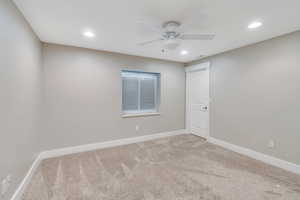 Carpeted empty room with ceiling fan